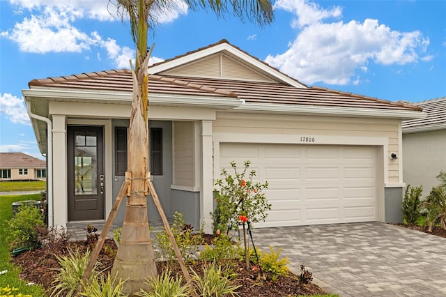 17800 Solstice Ave, Venice, FL 34293 - view of front of house featuring a garage, stucco siding, decorative driveway, and a tile roof