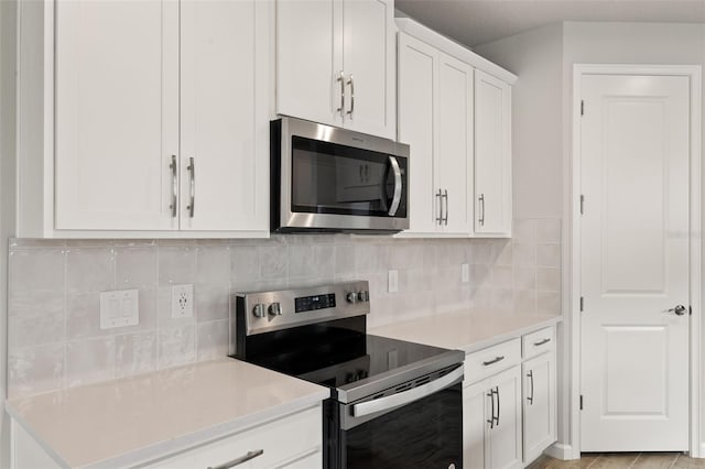 17800 Solstice Ave, Venice, FL 34293 - kitchen featuring appliances with stainless steel finishes, light countertops, backsplash, and white cabinets
