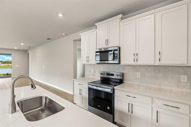 17800 Solstice Ave, Venice, FL 34293 - kitchen with tasteful backsplash, visible vents, appliances with stainless steel finishes, light countertops, and a sink