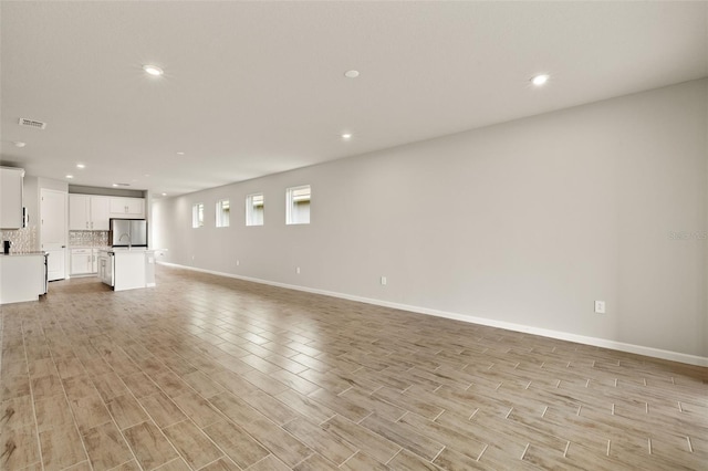 17800 Solstice Ave, Venice, FL 34293 - unfurnished living room featuring visible vents, baseboards, recessed lighting, and light wood-style floors