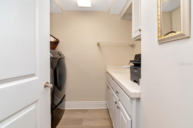 1350 Gulf Blvd Unit 301, Clearwater Beach, FL 33767 - laundry area with cabinet space, light wood-style flooring, and baseboards