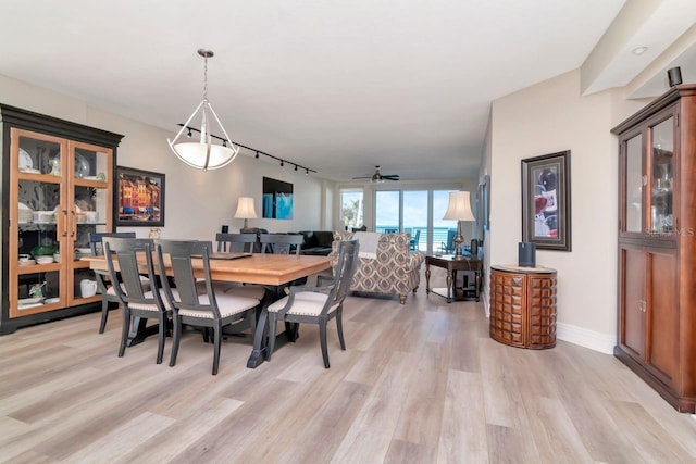 1350 Gulf Blvd Unit 301, Clearwater Beach, FL 33767 - dining area with light wood finished floors, a ceiling fan, baseboards, and rail lighting