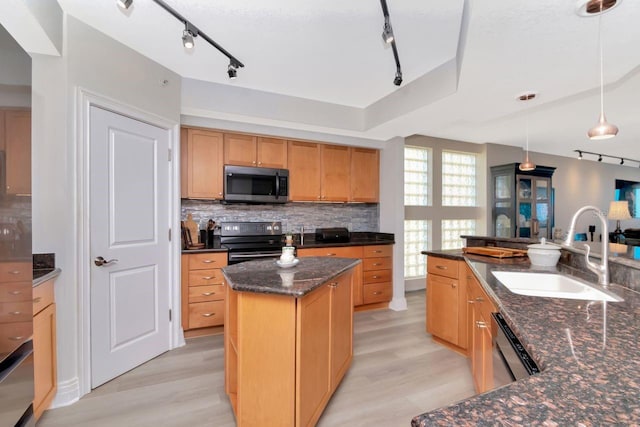 1350 Gulf Blvd Unit 301, Clearwater Beach, FL 33767 - kitchen featuring track lighting, a sink, tasteful backsplash, light wood-style flooring, and appliances with stainless steel finishes