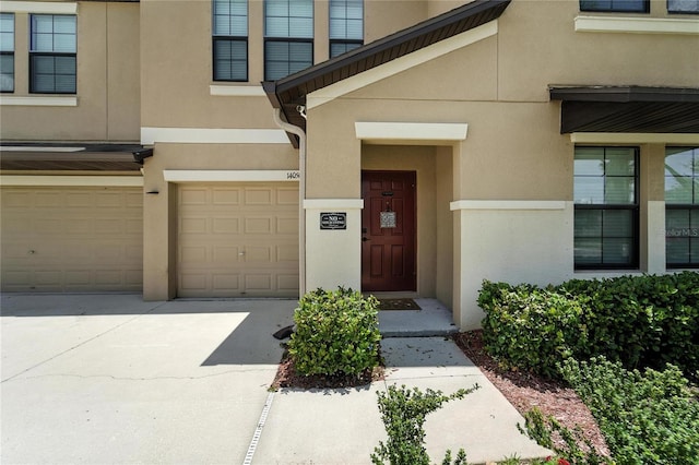 14050 Arbor Pines Dr, Riverview, FL 33579 - property entrance with stucco siding, an attached garage, and driveway