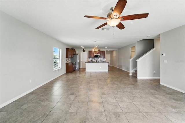14050 Arbor Pines Dr, Riverview, FL 33579 - unfurnished living room featuring a ceiling fan, stairway, and a chandelier