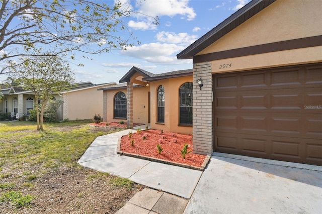 view of front facade featuring a garage, stucco siding, and driveway