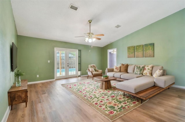 living room with light wood-type flooring, baseboards, french doors, and visible vents