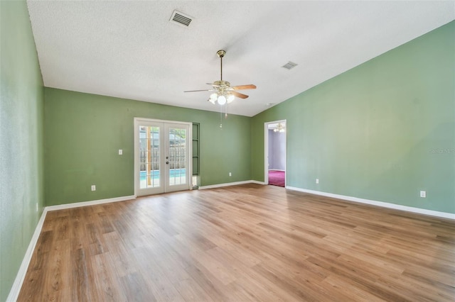 spare room with french doors, a ceiling fan, light wood-type flooring, and visible vents
