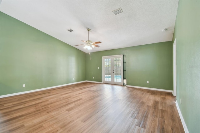 unfurnished room with ceiling fan, french doors, visible vents, and wood finished floors