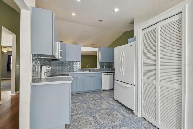 kitchen with freestanding refrigerator, dishwashing machine, vaulted ceiling, decorative backsplash, and stove