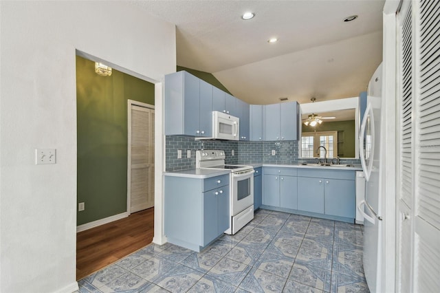 kitchen featuring white appliances, blue cabinets, a sink, decorative backsplash, and light countertops