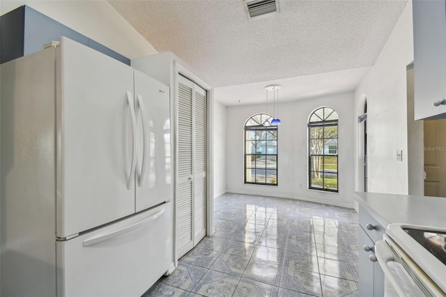 kitchen featuring marble finish floor, white appliances, visible vents, and a textured ceiling