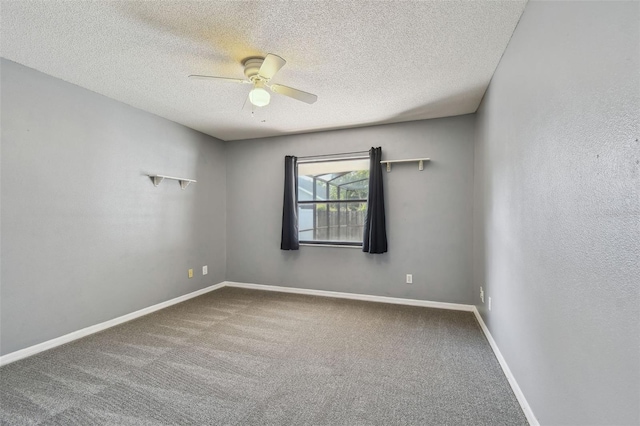empty room with ceiling fan, a textured ceiling, carpet flooring, and baseboards