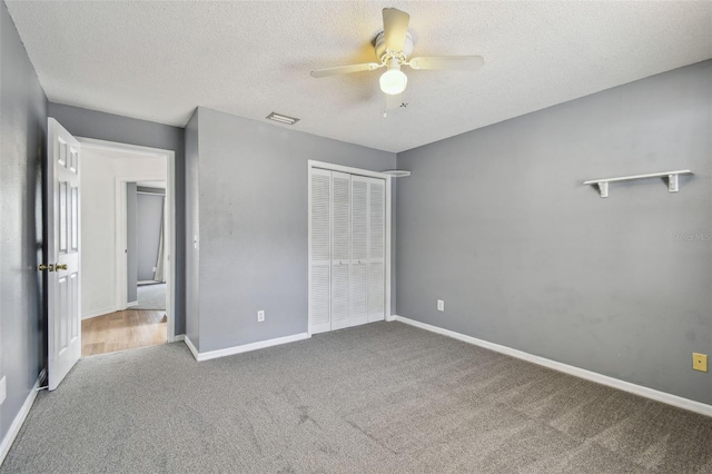unfurnished bedroom featuring carpet flooring, a closet, visible vents, and a textured ceiling