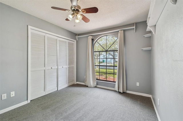 unfurnished bedroom featuring baseboards, carpet flooring, a closet, and a textured ceiling