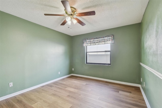 empty room featuring baseboards, a ceiling fan, a textured ceiling, and wood finished floors