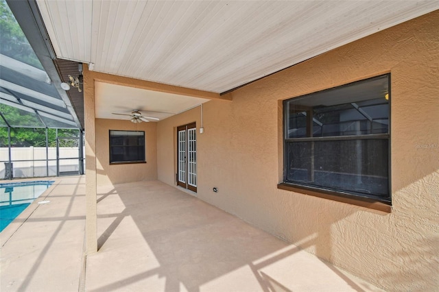 view of patio / terrace featuring a fenced in pool, glass enclosure, and ceiling fan