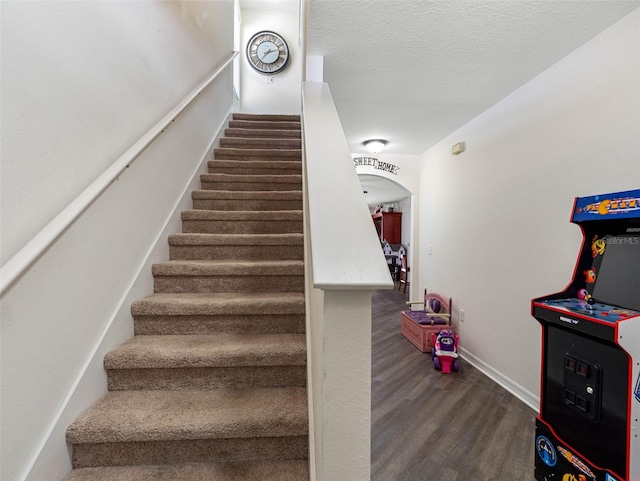 5946 81st Ave N, Pinellas Park, FL 33781 - staircase with arched walkways, baseboards, a textured ceiling, and wood finished floors