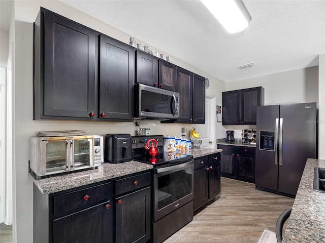 5946 81st Ave N, Pinellas Park, FL 33781 - kitchen featuring light stone counters, appliances with stainless steel finishes, light wood-style flooring, a toaster, and visible vents