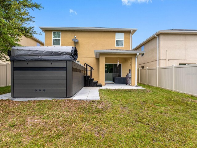 5946 81st Ave N, Pinellas Park, FL 33781 - rear view of property featuring stucco siding, a hot tub, fence, a patio, and a yard