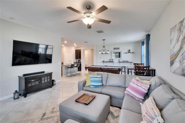 living room featuring light tile patterned flooring, visible vents, ceiling fan, and baseboards
