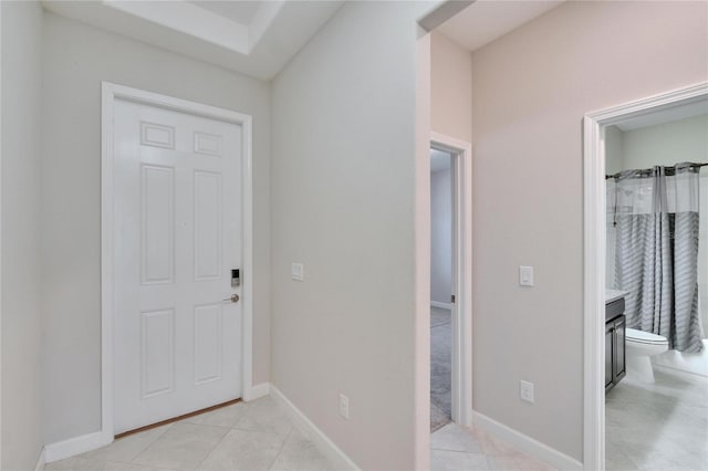 foyer with light tile patterned floors and baseboards