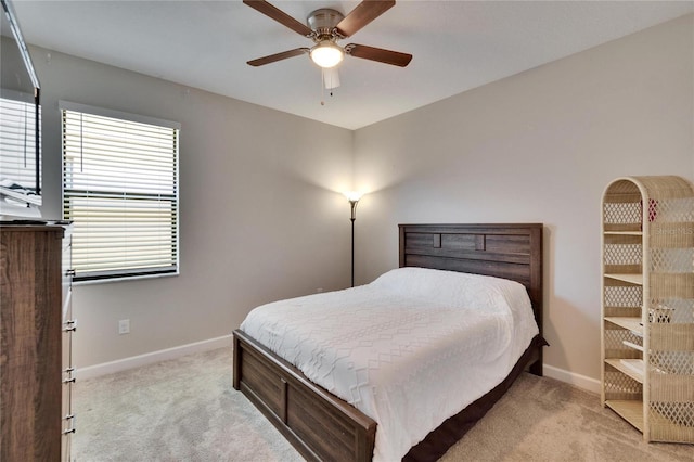 bedroom with ceiling fan, baseboards, and light carpet