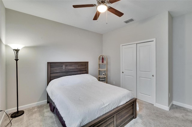 bedroom featuring a closet, visible vents, light colored carpet, and baseboards