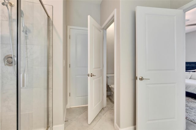 ensuite bathroom with tile patterned floors, a shower stall, toilet, and ensuite bathroom