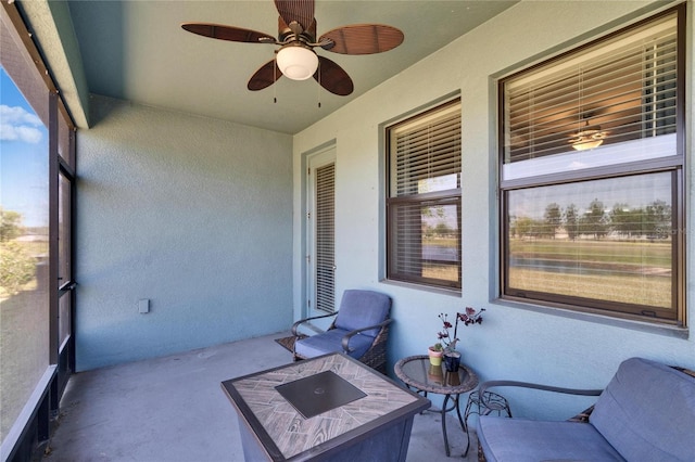 unfurnished sunroom with ceiling fan