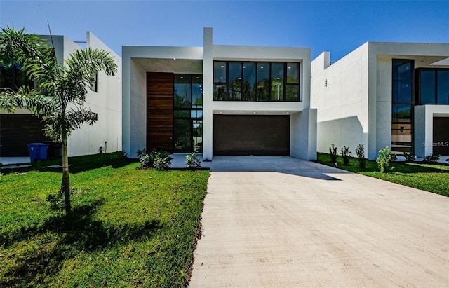 88 Avonwood, Tampa, FL 33625 - contemporary house featuring driveway, stucco siding, a front yard, and an attached garage