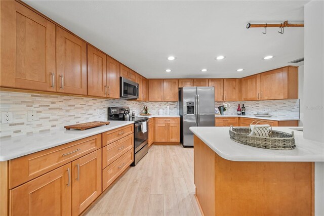 1810 Pine Hill Dr, Safety Harbor, FL 34695 - kitchen featuring stainless steel appliances, light wood-style floors, recessed lighting, tasteful backsplash, and light countertops