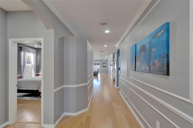 2510 Cross More St, Valrico, FL 33594 - corridor featuring light wood-type flooring, arched walkways, crown molding, and a wealth of natural light