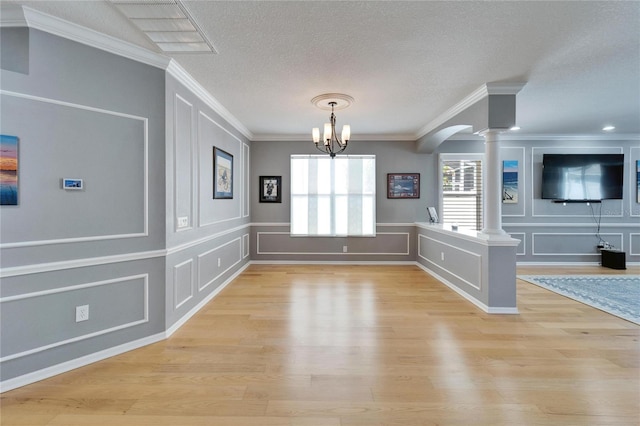 2510 Cross More St, Valrico, FL 33594 - unfurnished dining area with light wood-style floors, ornamental molding, decorative columns, and a decorative wall