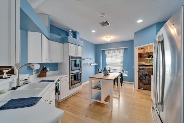 2510 Cross More St, Valrico, FL 33594 - kitchen with a sink, light countertops, washer / clothes dryer, stainless steel appliances, and visible vents