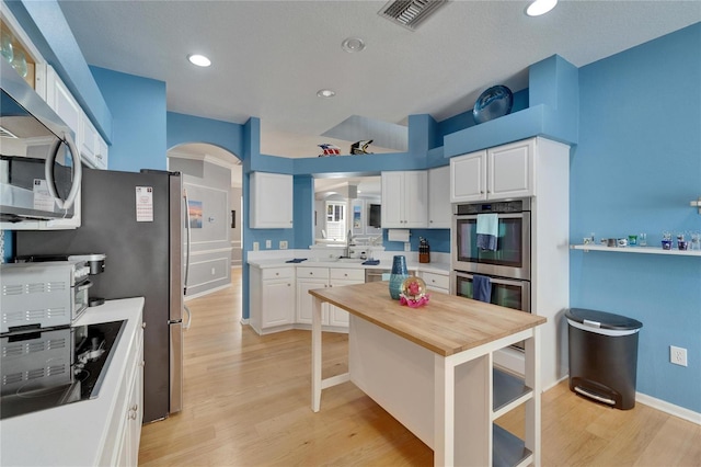 2510 Cross More St, Valrico, FL 33594 - kitchen featuring wooden counters, visible vents, appliances with stainless steel finishes, arched walkways, and light wood-style flooring
