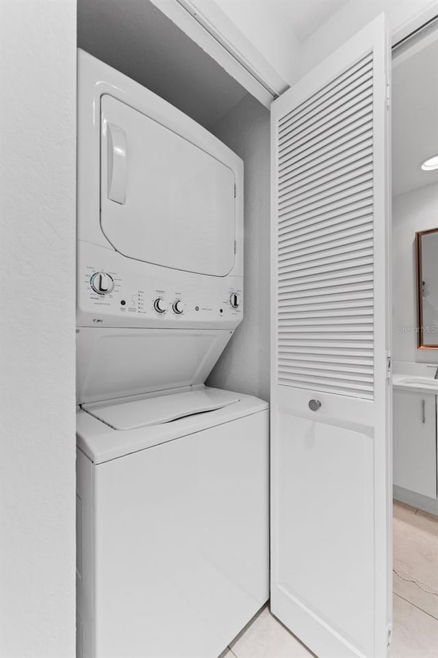 4750 Dolphin Cay Ln S Unit 209, Saint Petersburg, FL 33711 - laundry room featuring stacked washer and clothes dryer and light tile patterned floors