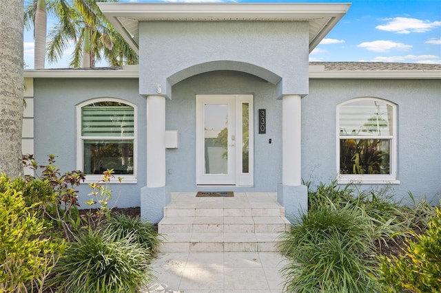 entrance to property featuring stucco siding