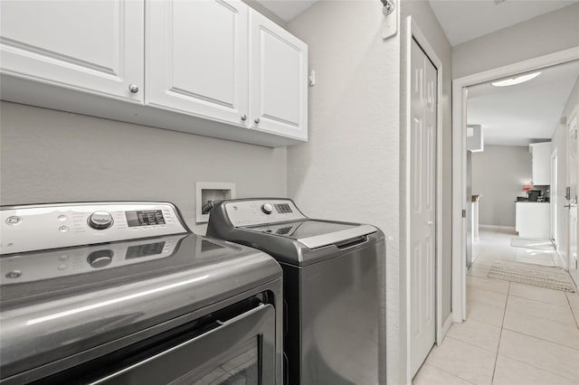 laundry room featuring light tile patterned floors, cabinet space, and independent washer and dryer