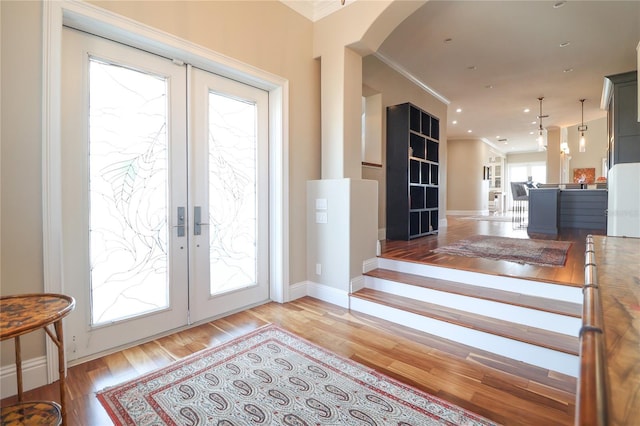 11105 5th St E, Treasure Island, FL 33706 - doorway featuring french doors, arched walkways, light wood-type flooring, baseboards, and ornamental molding
