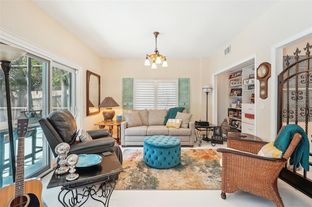living area with built in shelves, visible vents, and an inviting chandelier