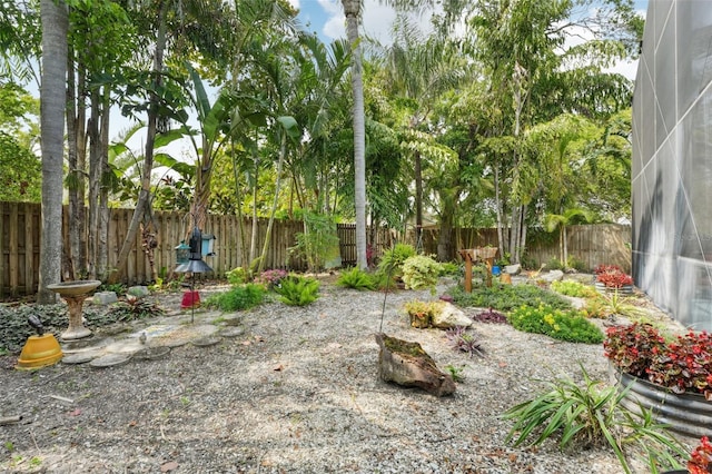 view of yard with glass enclosure and a fenced backyard