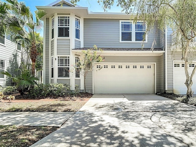 traditional-style home featuring concrete driveway and a garage
