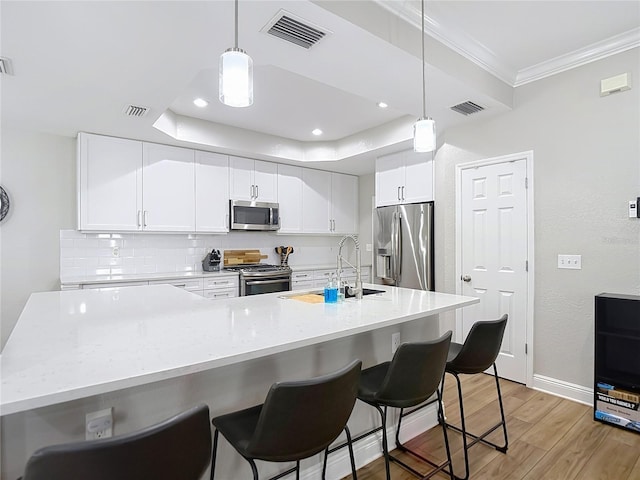 kitchen featuring appliances with stainless steel finishes, light wood-style flooring, visible vents, and ornamental molding