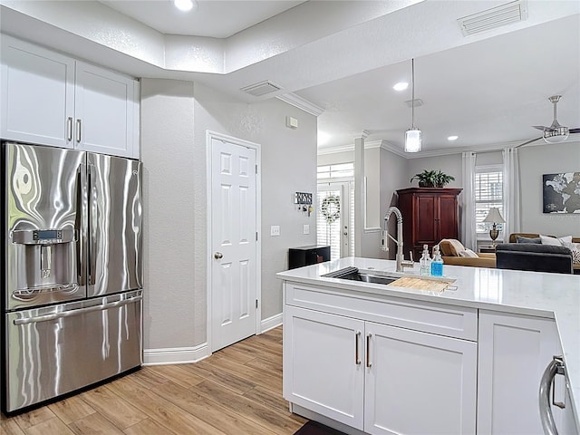 kitchen with a sink, visible vents, light wood-type flooring, and stainless steel fridge with ice dispenser