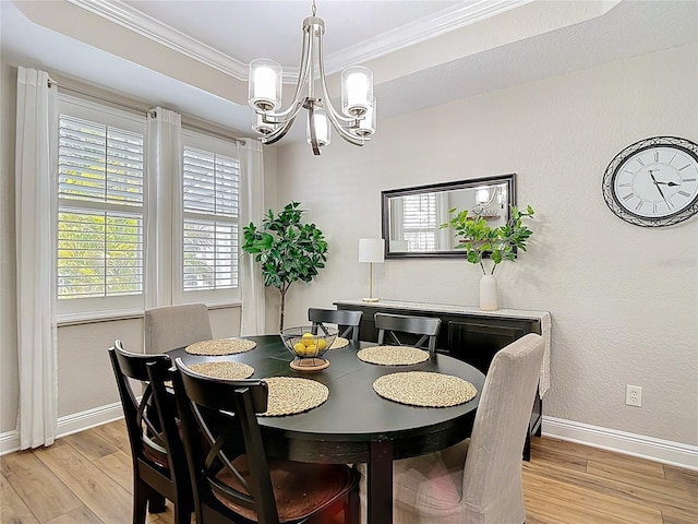 dining room featuring ornamental molding, an inviting chandelier, baseboards, and light wood-style floors