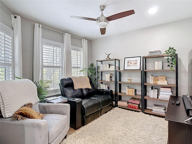 living area featuring wood finished floors and ceiling fan