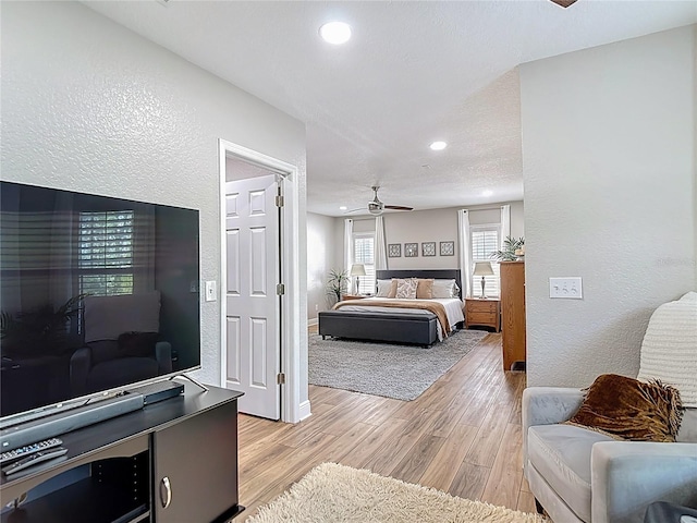 bedroom featuring a textured wall, light wood-type flooring, and recessed lighting