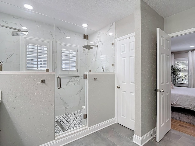ensuite bathroom featuring a textured ceiling, recessed lighting, ensuite bath, and a marble finish shower