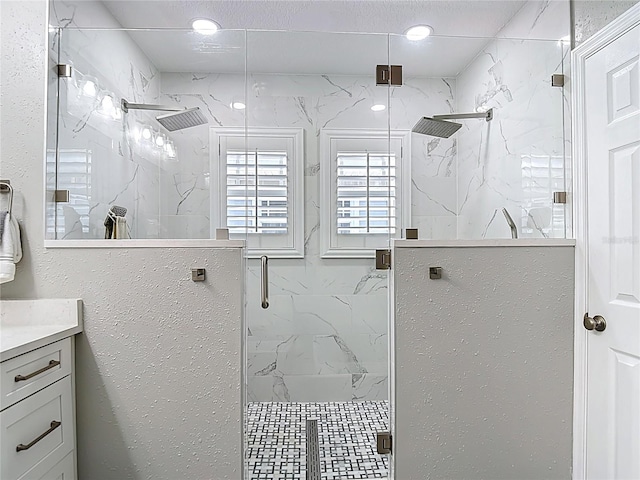 bathroom featuring vanity and a marble finish shower